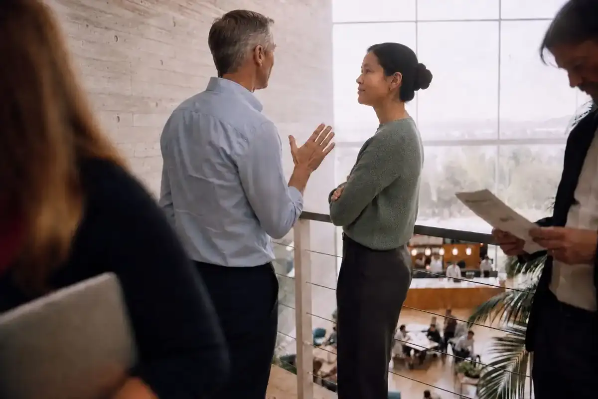 Colleagues in conversation on a mezzanine above an atrium